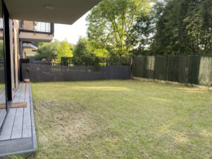 Privater Rasengarten mit Terrasse und Sichtschutzzaun des Apartments Rose Garden