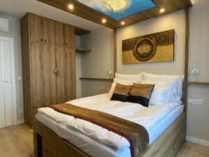 Schlafzimmer der Butterfly Suite mit Doppelbett, Kleiderschrank und beleuchtetem Mond-Deckenbild