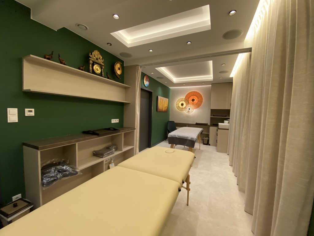 Tree Room im ARALIYA Krakau mit zwei Massageliegen, Regalen und dekorativen Fächerleuchten