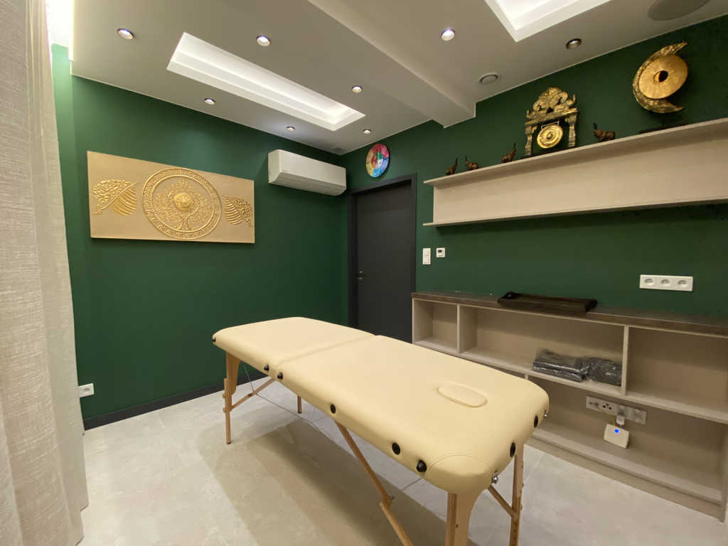Tree Room im ARALIYA Krakau mit Massageliege, goldenem Wandrelief und Dekoregal