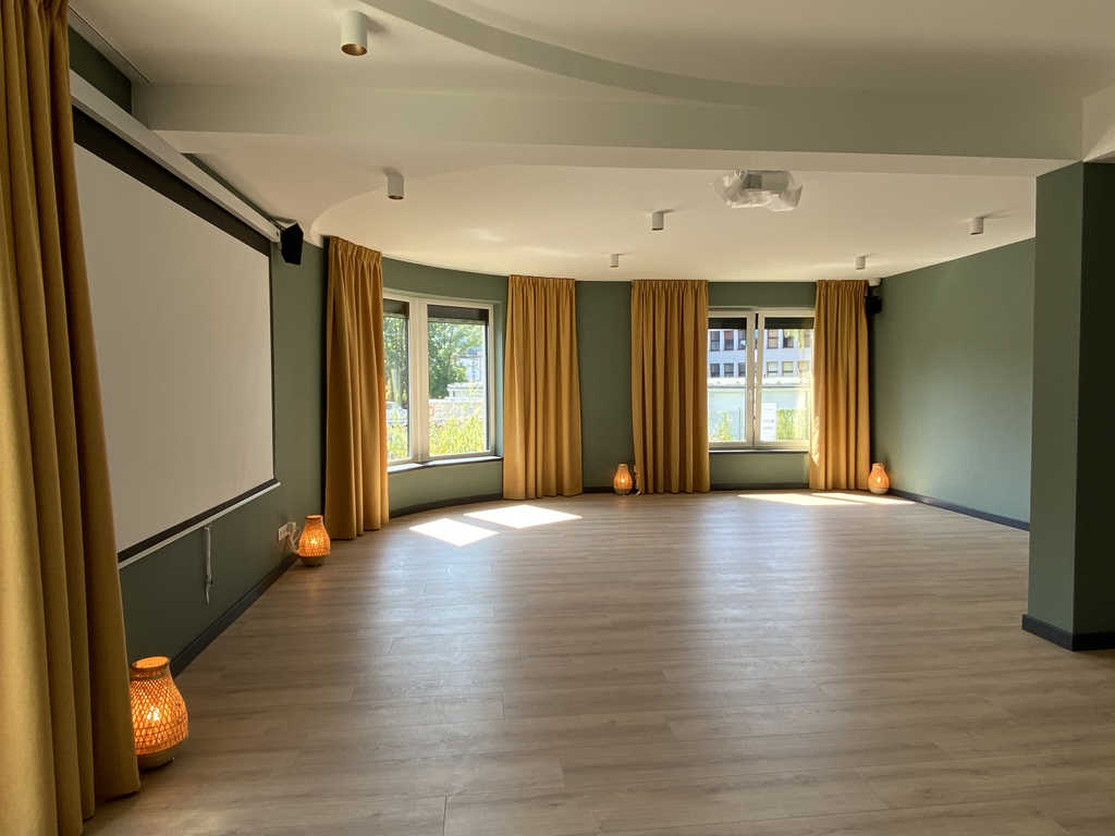 Großer Studioraum im ARALIYA Krakau mit Mittelsäule, Leinwand und Fensterfront